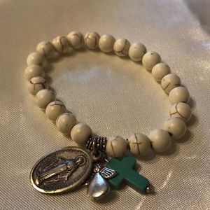 Stretchy; white antique looking beads; 3 charms